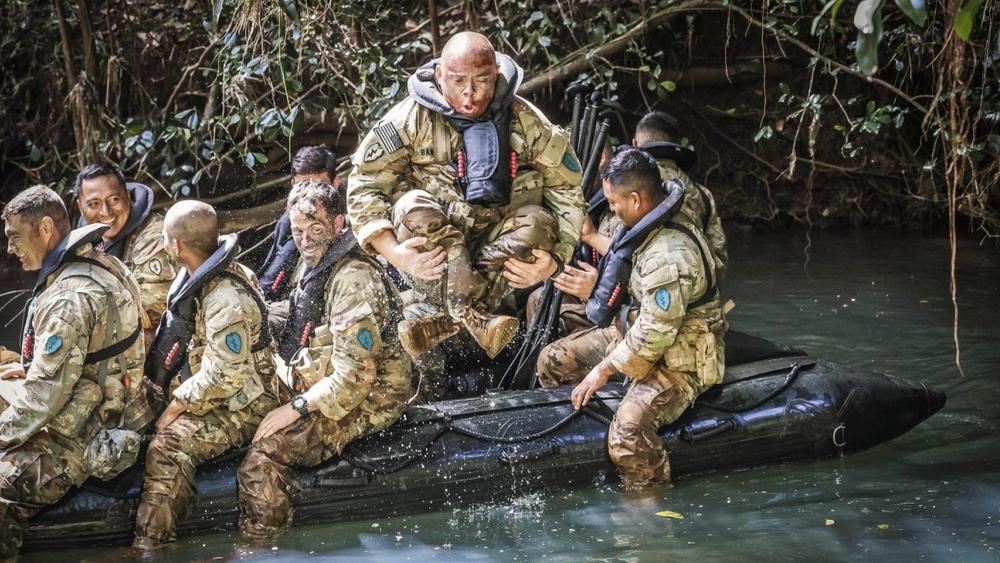 A soldier jumps out of a boat during competitive tactical events at Schofield Barracks, Hawaii, photo by Jessica Scott/U.S. Army