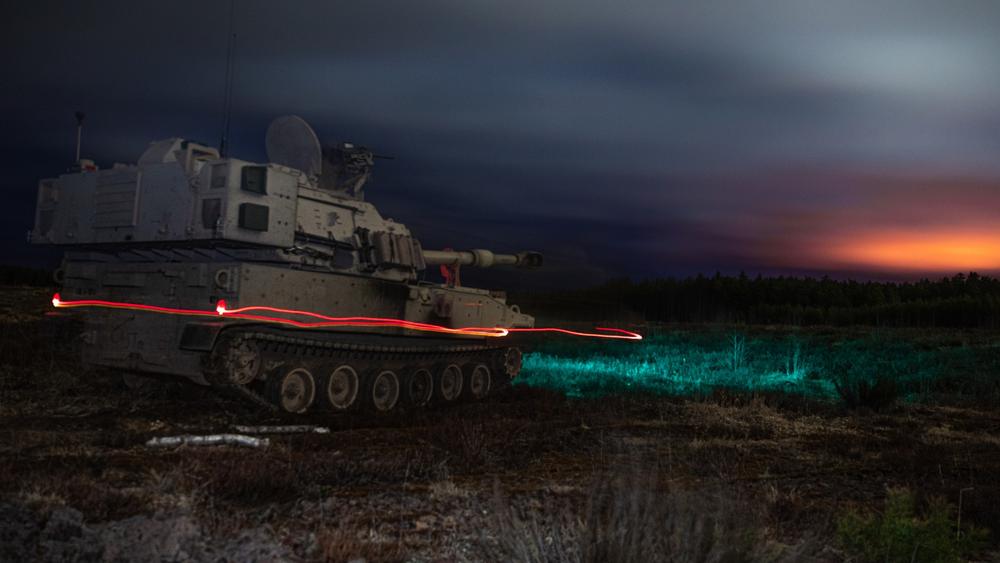 An M109A7 Self-Propelled Howitzer drives off after lighting the night sky with an illumination round during a training exercise, photo by Agustin Montanez/U.S. Army