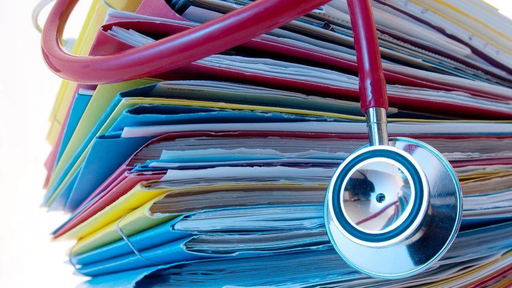 A stethoscope on a stack of medical files, photo by mario beauregard/Adobe Stock