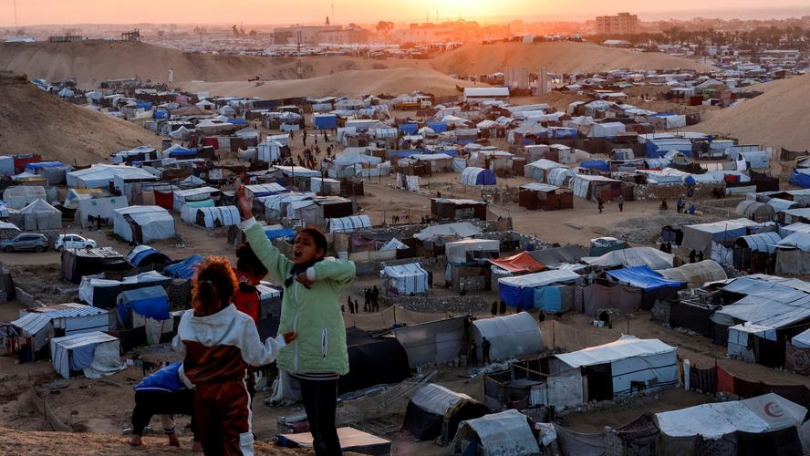 Displaced Palestinian children talk to each other as they shelter in a tent camp in Khan Younis, southern Gaza Strip, December 29, 2024, photo by Mohammed Salem/Reuters