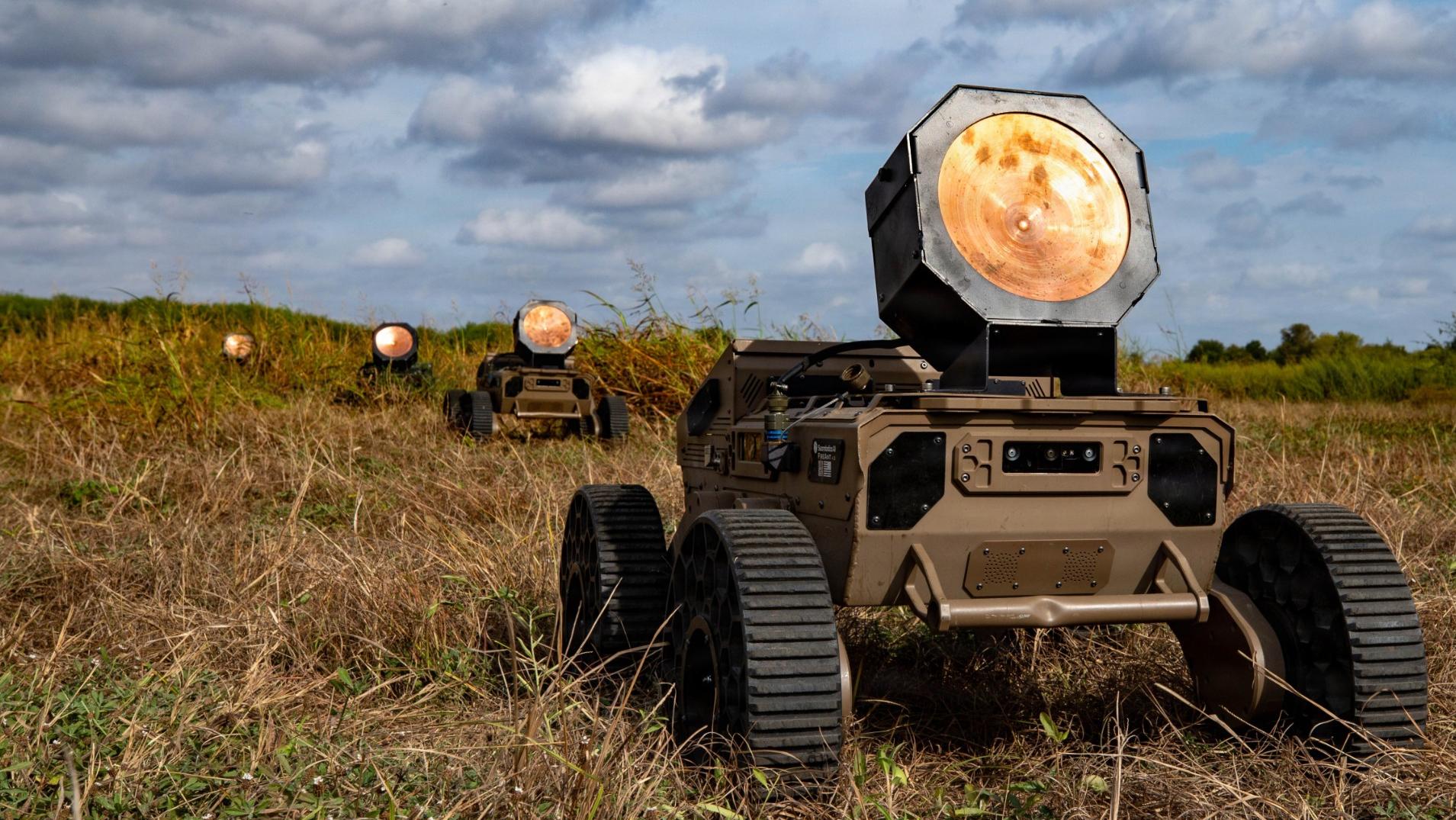 Swarmbotics AI "FireAnt" unmanned ground vehicles proceed in a line at the xTech Overwatch for Unmanned Systems event hosted by the U.S. Army Transformation and Training Command.
