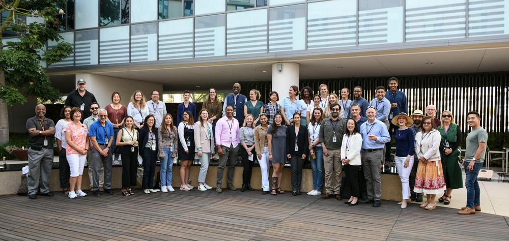 Large group of new hires posing in the courtyard of the Santa Monica Headquarters.