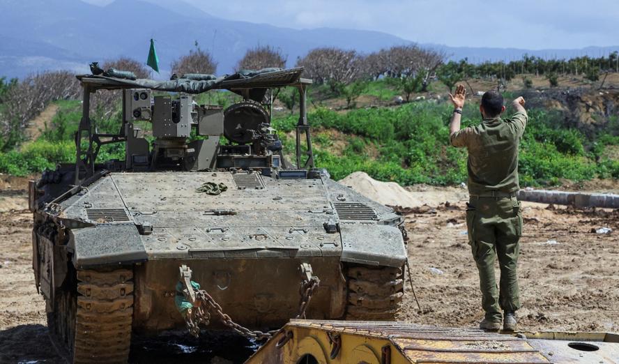 An Israeli soldier directs an armoured personnel carrier near the border with Lebanon amid escalating hostilities between Israel and Hezbollah, March 27, 2026