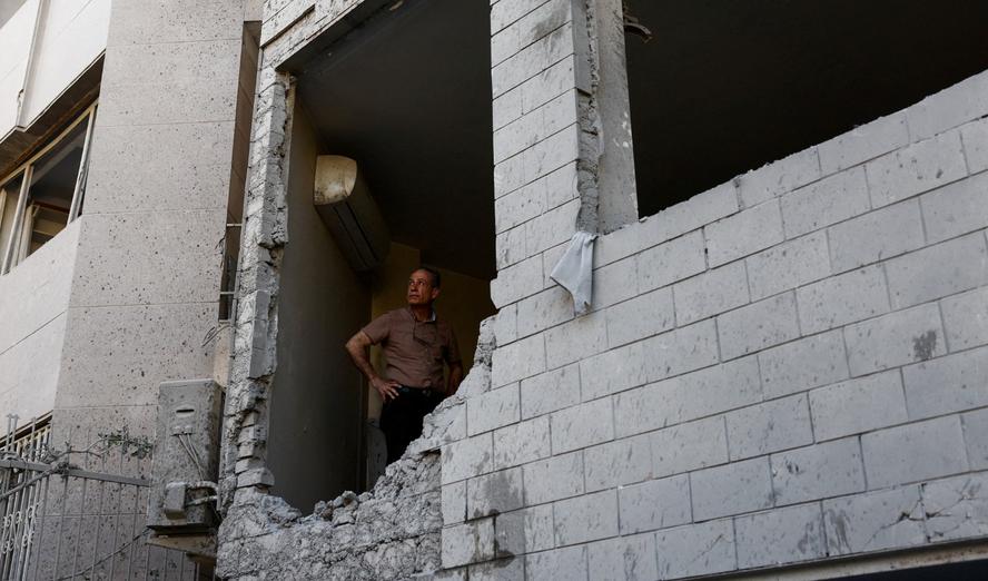 A man stands at his home, which was damaged in a strike amid the U.S.-Israeli conflict with Iran, Tehran, April 7, 2026.